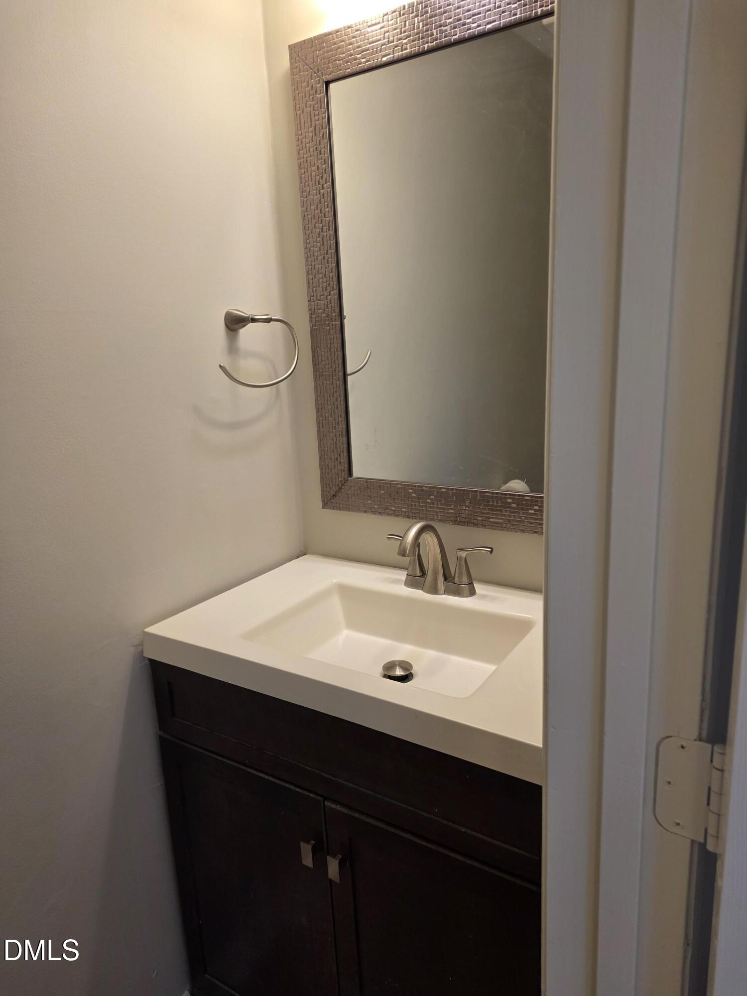 1717 Kayla Court Raleigh, NC 27606 - Photo 7 of 27 a bathroom with a sink and a mirror