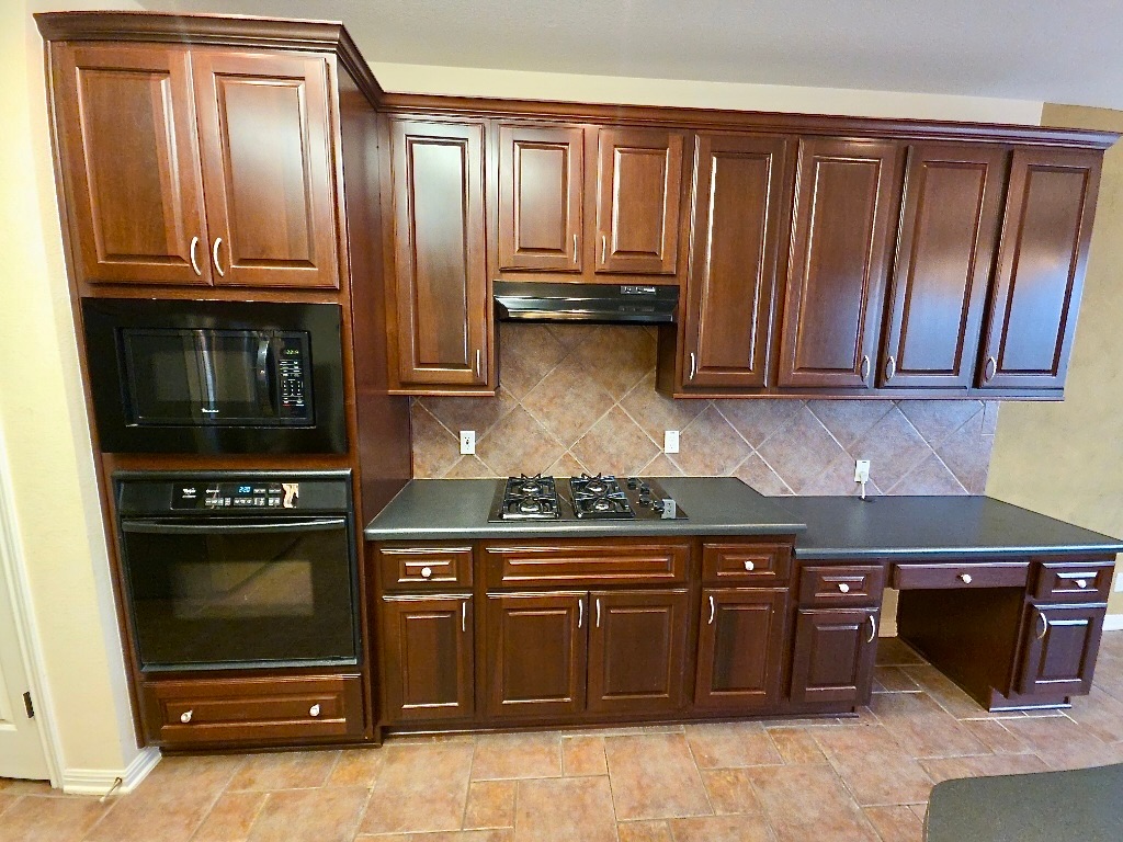 1103 Seton Hall Lane Pflugerville, TX 78660 - Photo 8 of 32 Kitchen with dark countertops, black appliances, backsplash, and dark brown cabinets