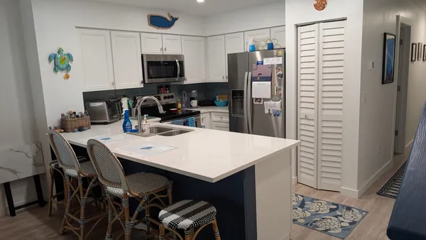 a kitchen with a table chairs refrigerator and microwave