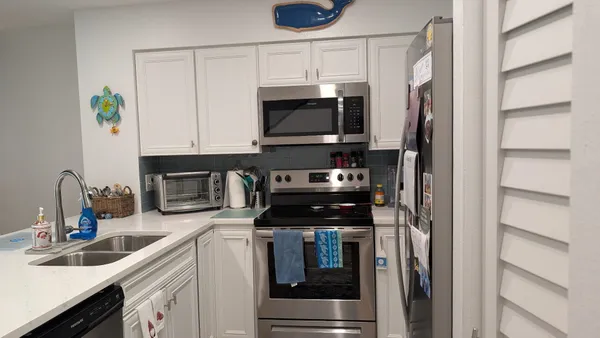 a kitchen with stainless steel appliances a stove a microwave and a sink
