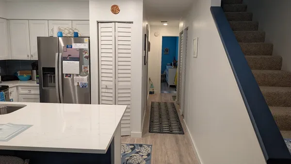 a view of kitchen with refrigerator stove and wooden floor