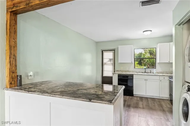 a kitchen with granite countertop a sink stove and cabinets