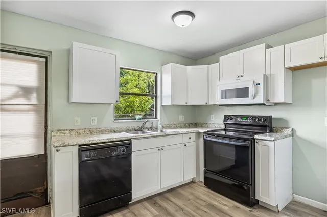 a kitchen with a stove sink and cabinets