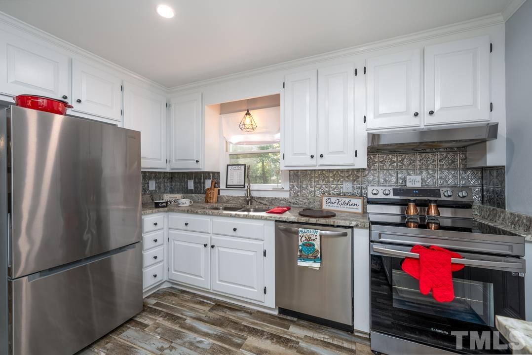 507 Valley Drive Durham, NC 27704 - Photo 10 of 29 a kitchen with stainless steel appliances granite countertop a refrigerator a stove a sink and white cabinets