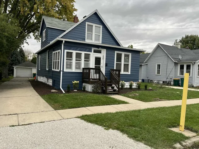 a front view of a house with a yard table and chairs