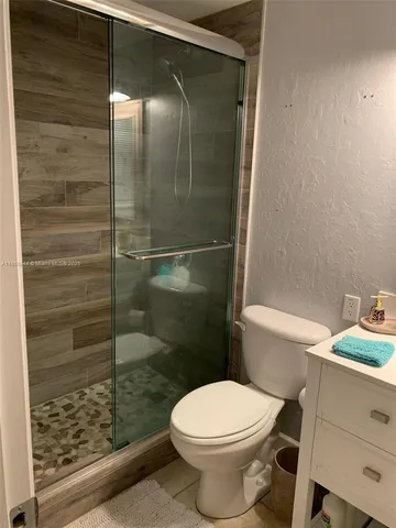 a bathroom with a toilet and a shower