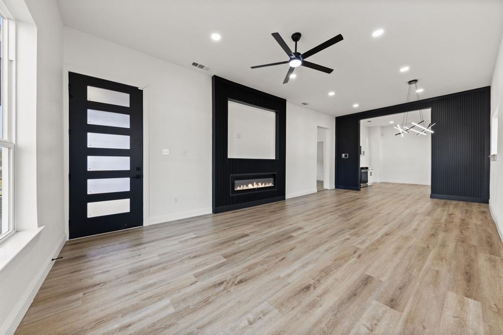 1279 Bonham Street Paris, TX 75460 - Photo 3 of 15 a view of an empty room with wooden floor and a ceiling fan