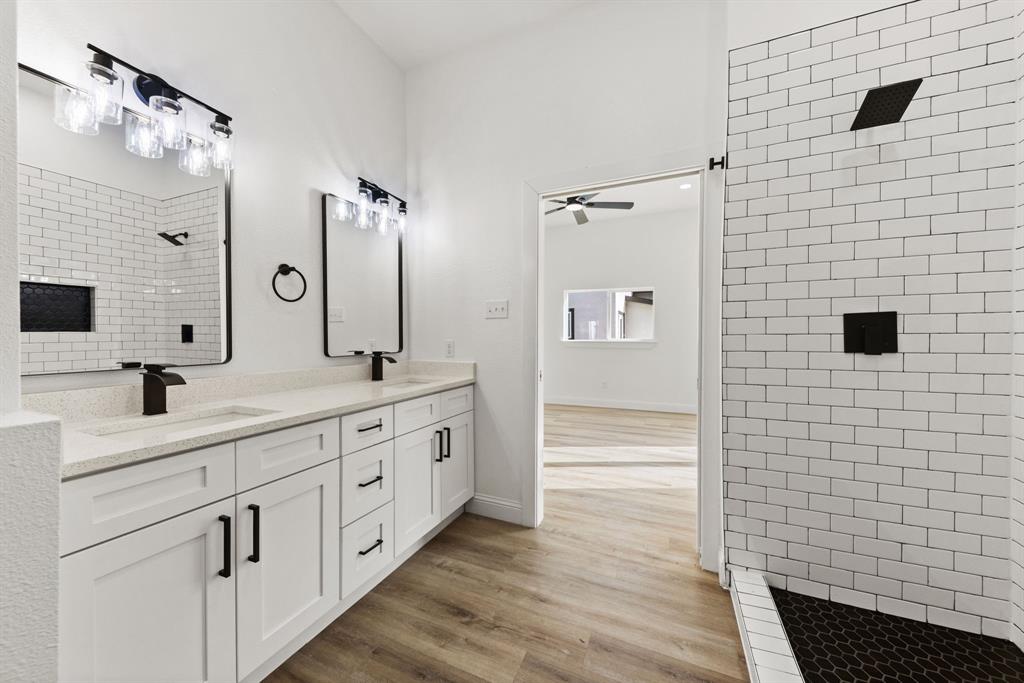1279 Bonham Street Paris, TX 75460 - Photo 9 of 15 a bathroom with a double vanity sink a mirror and shower