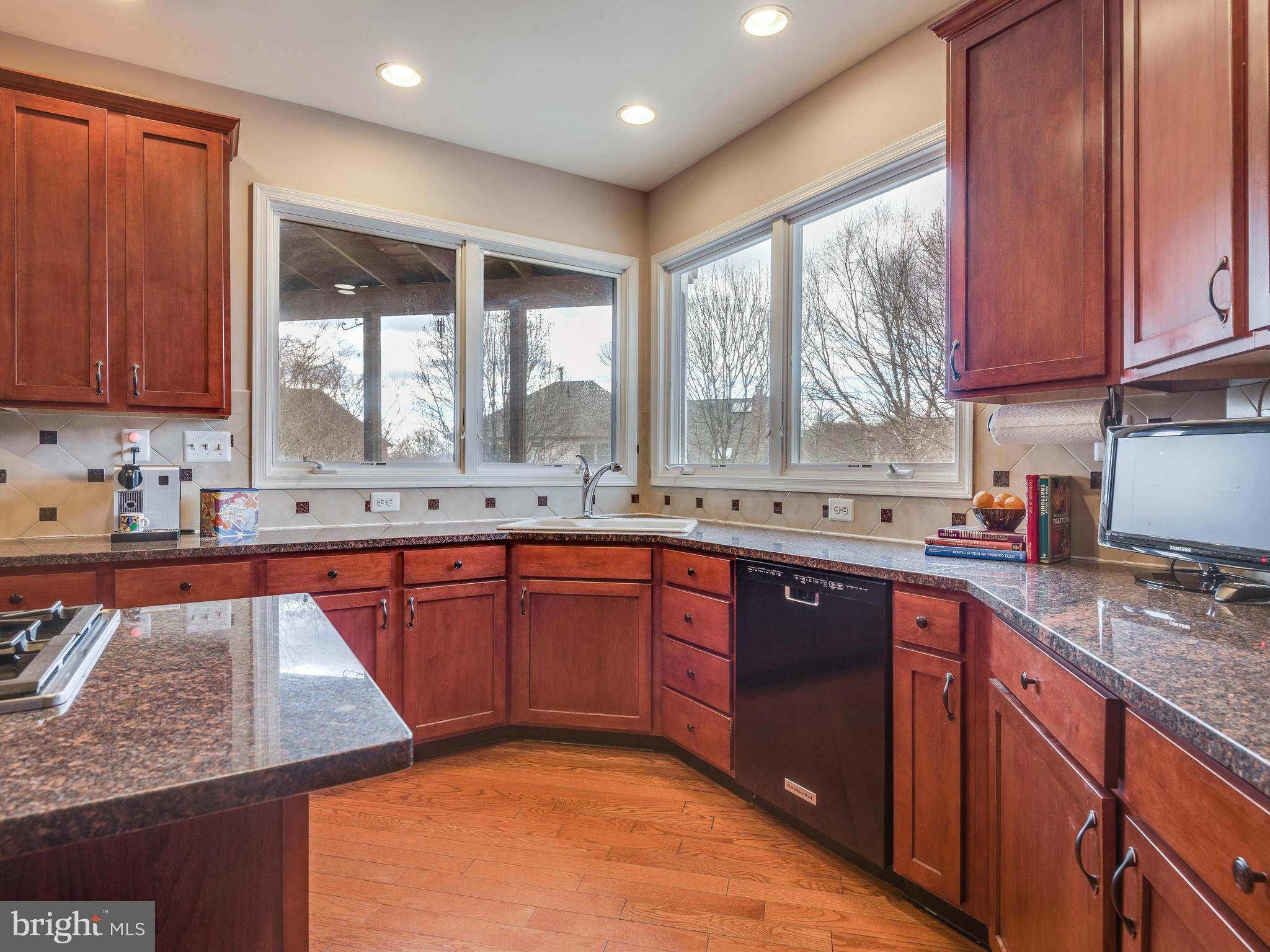 10889 Hunter Gate Way Reston, VA 20194 - Photo 7 of 30 a kitchen with stainless steel appliances granite countertop wooden cabinets a sink and dishwasher with wooden floor