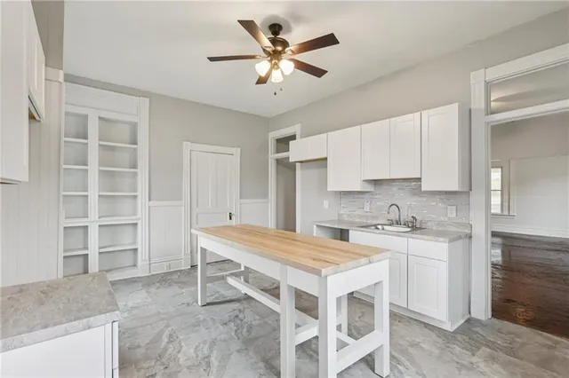 a kitchen with a table chairs sink and cabinets