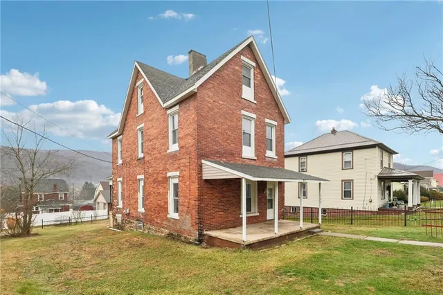 a view of a house with a yard and sitting area