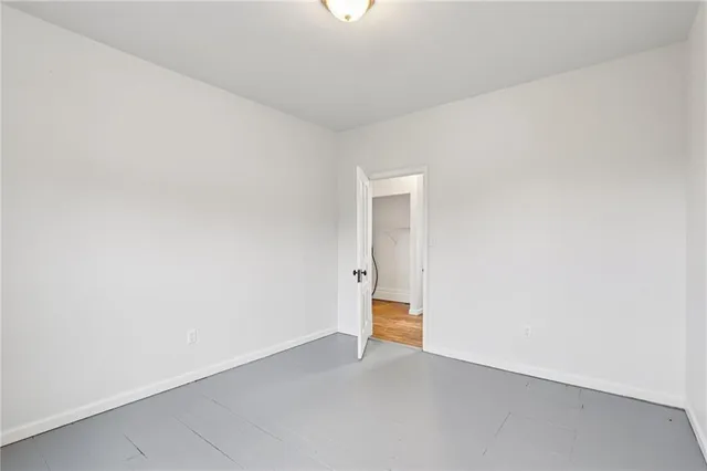 an empty room with wooden floor and window