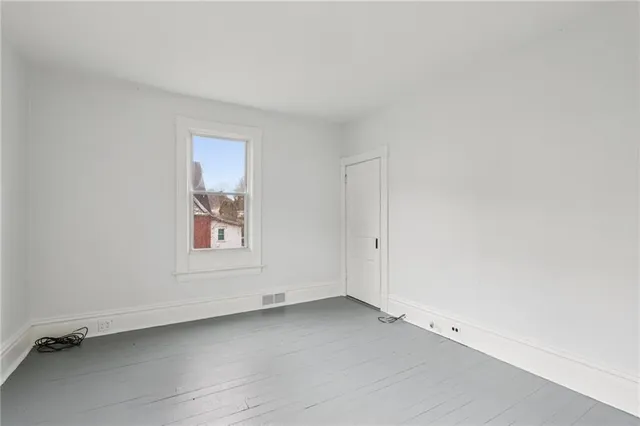 a view of a hallway with wooden floor and entryway