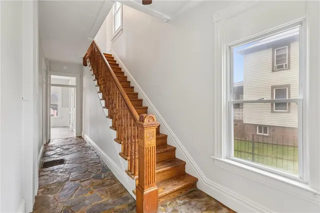 a view of staircase with railing and white walls
