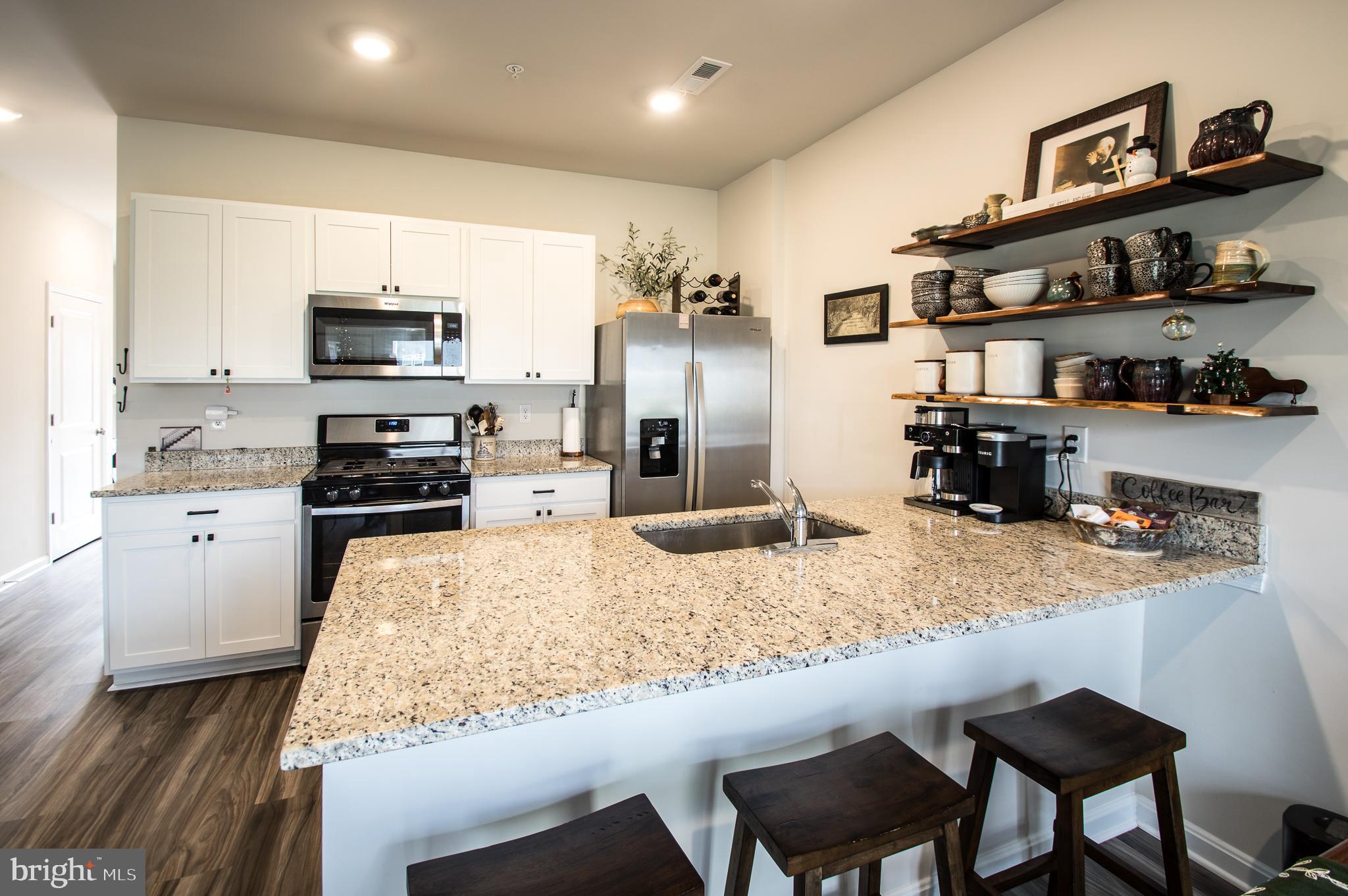 345 Maple Run Drive York, PA 17404 - Photo 10 of 26 a kitchen with stainless steel appliances granite countertop a stove top oven a sink a dining table and chairs