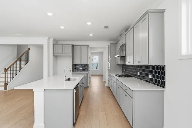 a kitchen with stainless steel appliances a sink stove and cabinets