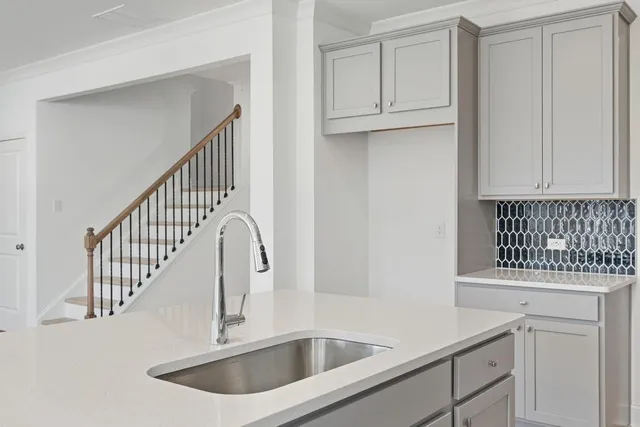 a kitchen with white cabinets sink and a window