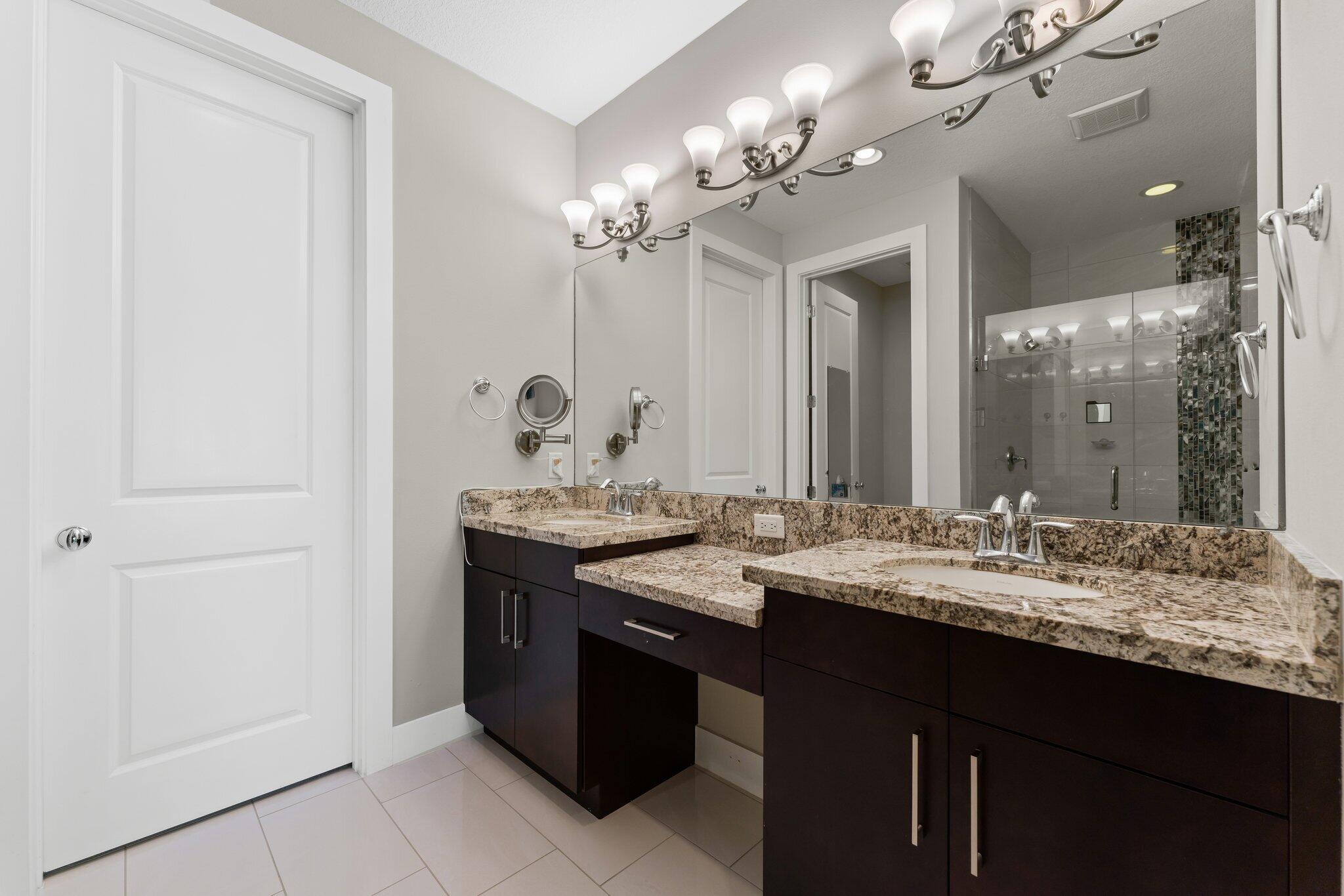 13364 Alton Road Palm Beach Gardens, FL 33418 - Photo 29 of 58 a bathroom with a granite countertop sink a large mirror and a shower