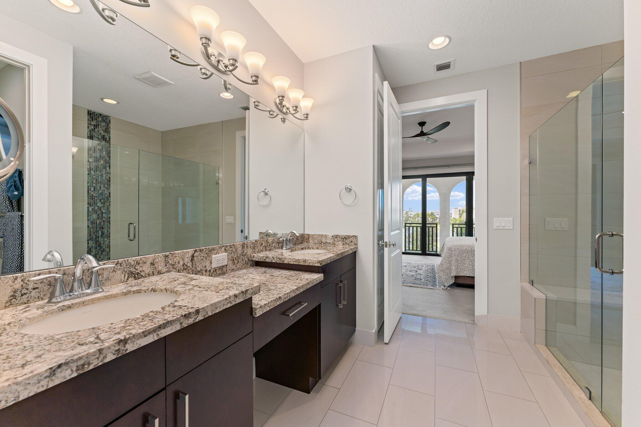 13364 Alton Road Palm Beach Gardens, FL 33418 - Photo 30 of 58 a spacious bathroom with a granite countertop sink a mirror and a shower