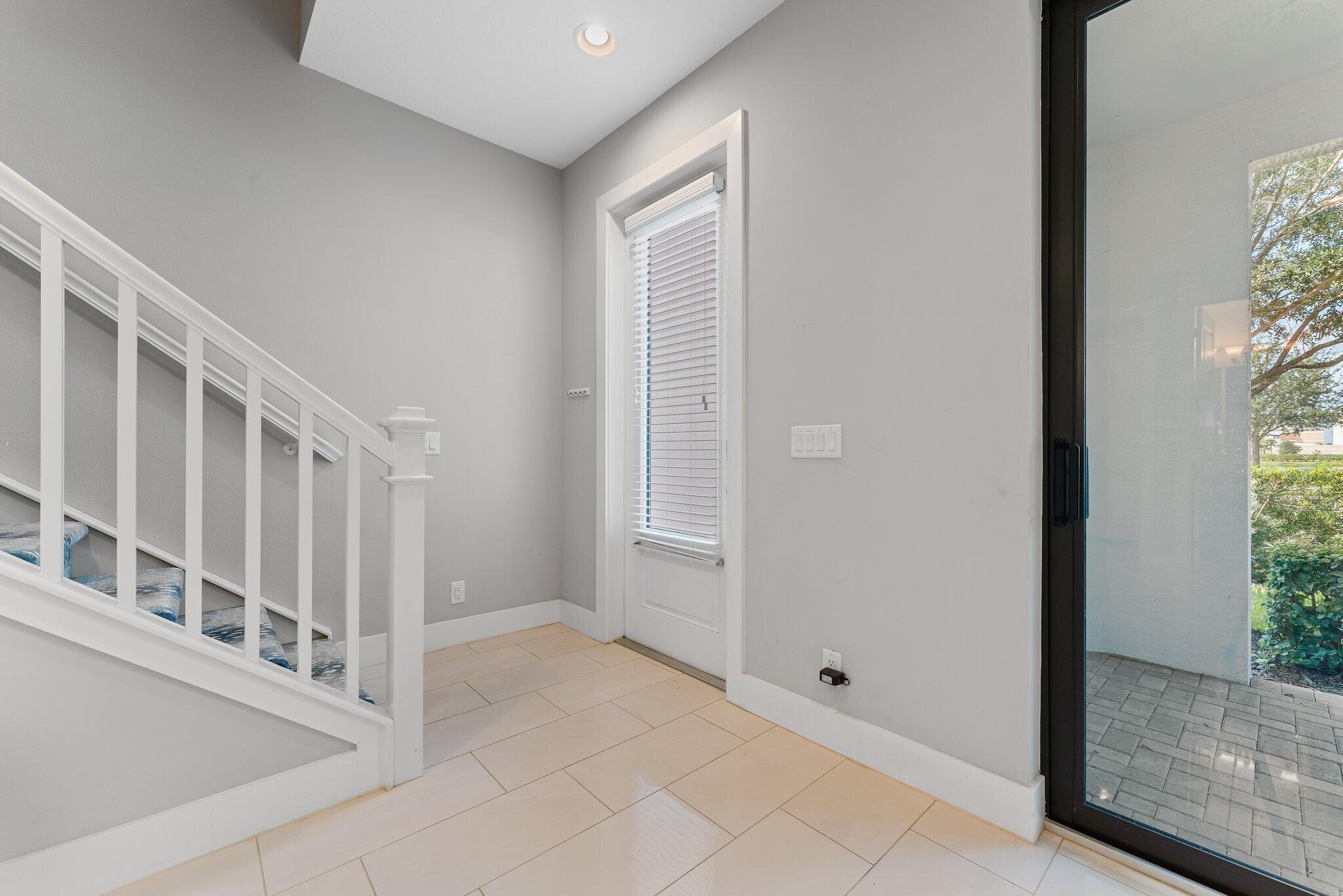 13364 Alton Road Palm Beach Gardens, FL 33418 - Photo 6 of 58 a view of staircase with white walls and windows
