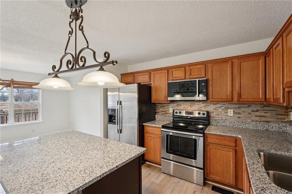38 Middleton Court Cartersville, GA 30120 - Photo 15 of 46 a kitchen with stainless steel appliances granite countertop a stove a sink and a microwave
