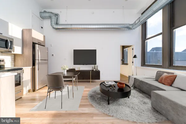 a living room with furniture a rug and a flat screen tv
