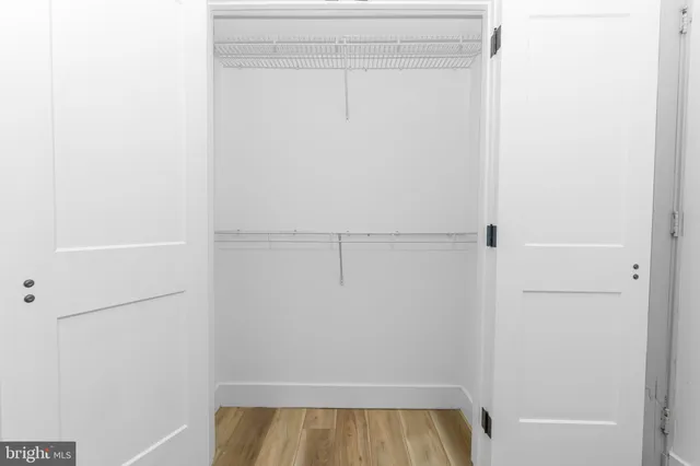 a view of walk in closet with empty racks