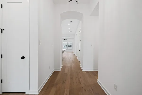 a view of a hallway with wooden floor