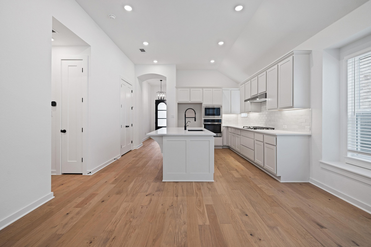 120 Fox Run Georgetown, TX 78628 - Photo 13 of 30 a large kitchen with stainless steel appliances granite countertop a large center island a stove a refrigerator white cabinets and wooden floor