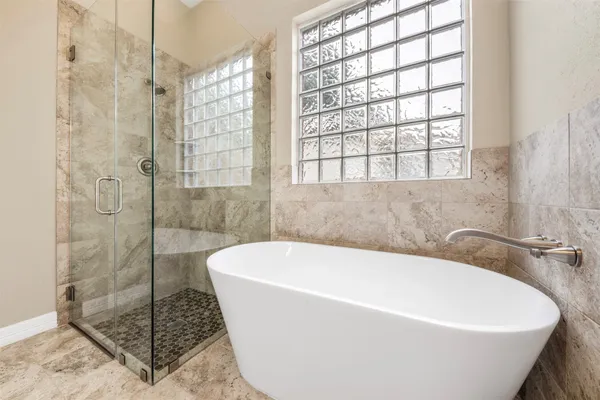 a white bath tub sitting next to a shower