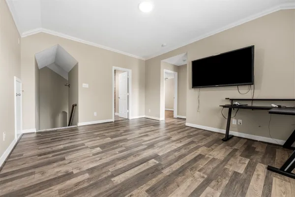 a view of a livingroom with wooden floor and a flat screen tv