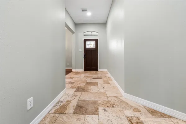 a view of a hallway with wooden floor and a bathroom