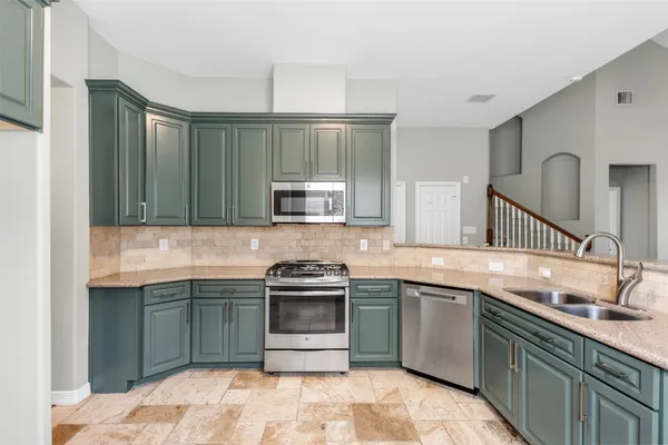 a kitchen with stainless steel appliances granite countertop a sink stove and cabinets
