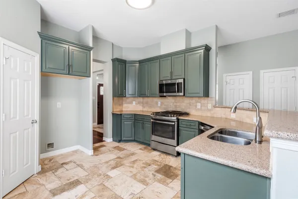 a kitchen with stainless steel appliances granite countertop a sink stove and refrigerator