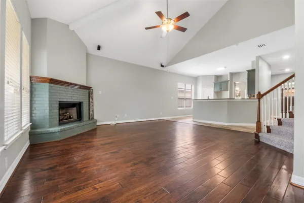 a view of empty room with wooden floor and fireplace