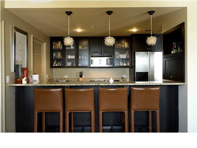 34 The Lofts In Barrett Square, Unit 2E Rosemary Beach, FL 32461 - Photo 3 of 12 a kitchen with a table chairs refrigerator and microwave