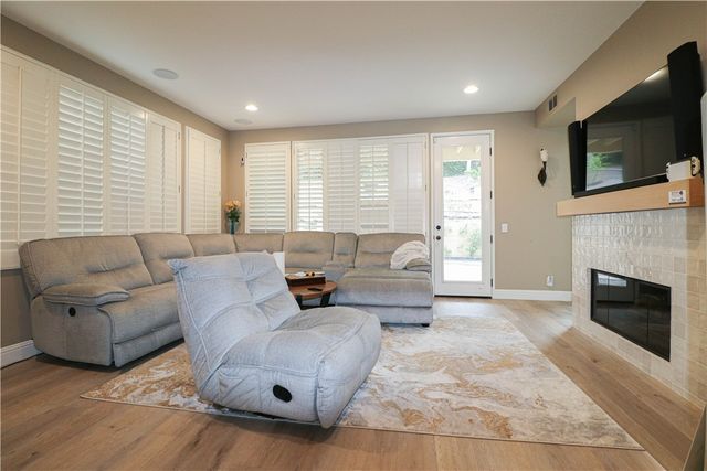 a living room with furniture a flat screen tv and a fireplace