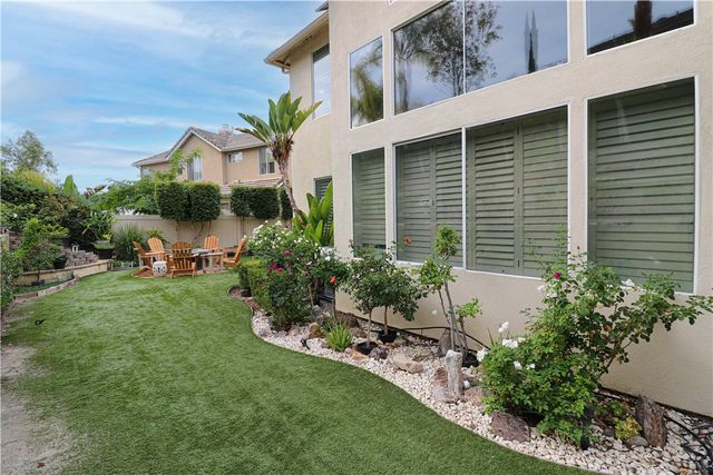 a view of a house with a yard and potted plants