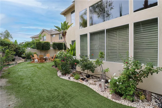 a view of a house with a yard and potted plants