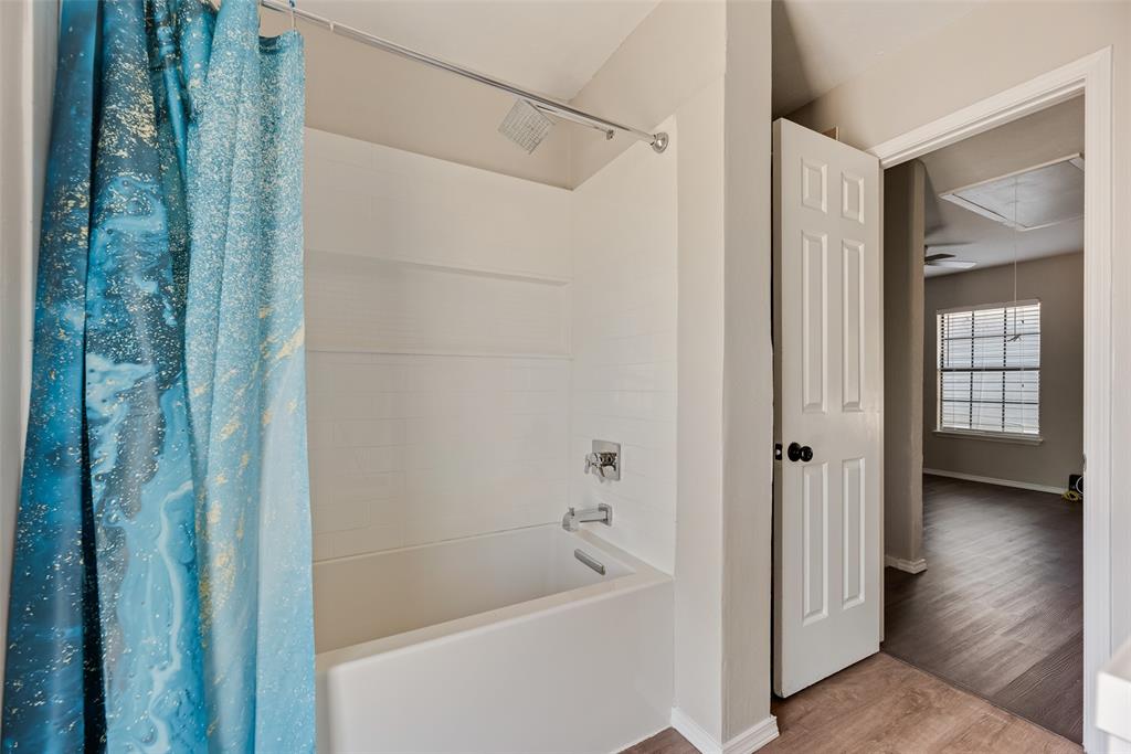 11136 McCree Road Dallas, TX 75238 - Photo 14 of 21 a bathroom with a bathtub and a shower