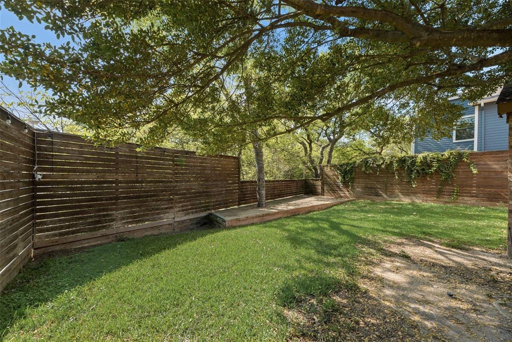 11136 McCree Road Dallas, TX 75238 - Photo 2 of 21 a view of a backyard with wooden fence and a large tree