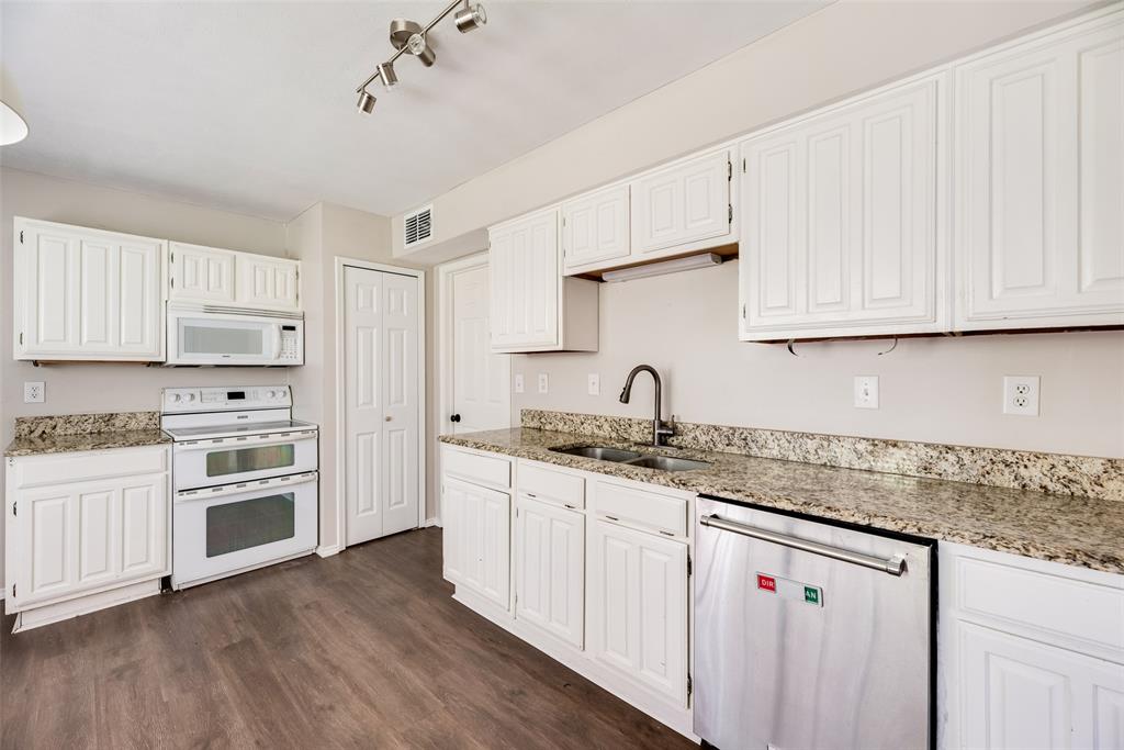 11136 McCree Road Dallas, TX 75238 - Photo 4 of 21 a kitchen with granite countertop white cabinets and white appliances