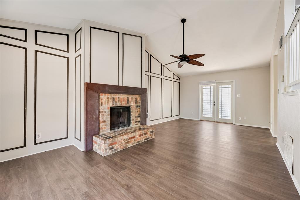 11136 McCree Road Dallas, TX 75238 - Photo 5 of 21 a view of empty room with fireplace and wooden floor