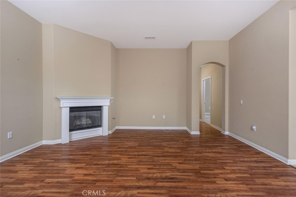 7692 Dutra Drive Hemet, CA 92545 - Photo 21 of 48 a view of an empty room with wooden floor fireplace and a window