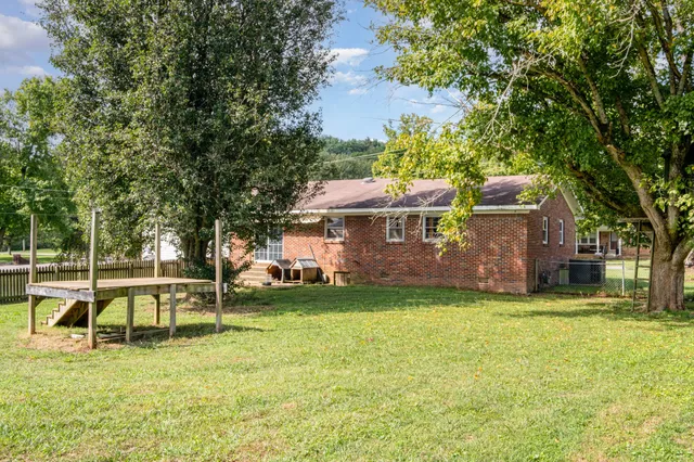 a view of a house with a big yard and sitting area