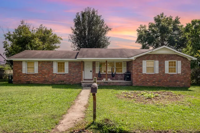 a front view of a house with a garden and porch