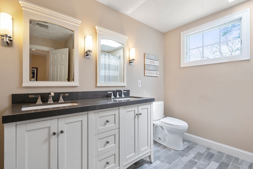 22 Fox Run Road Sudbury, MA 01776 - Photo 27 of 42 a bathroom with a granite countertop sink a toilet and a mirror