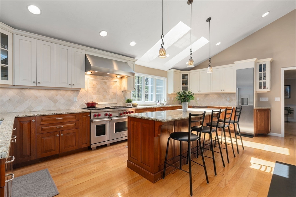 22 Fox Run Road Sudbury, MA 01776 - Photo 8 of 42 a kitchen with stainless steel appliances granite countertop a stove top oven a sink a dining table and chairs with wooden floor