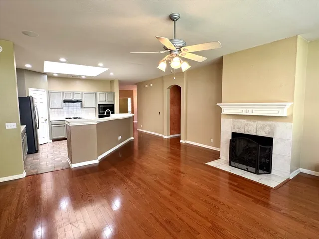 a view of a kitchen with wooden floor and a fireplace