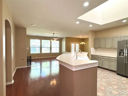 a large kitchen with a sink and a large window